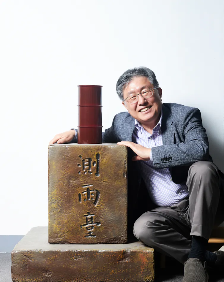 Professor Mooyoung Han posing next to a replica of the Cheugugi, Korea’s historic rain gauge, at the Rainwater Research Center.