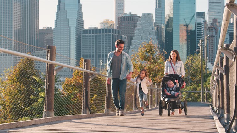 Family walking with cityscape background.