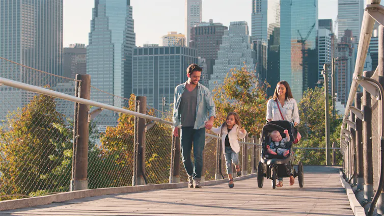 Family walking with cityscape background.