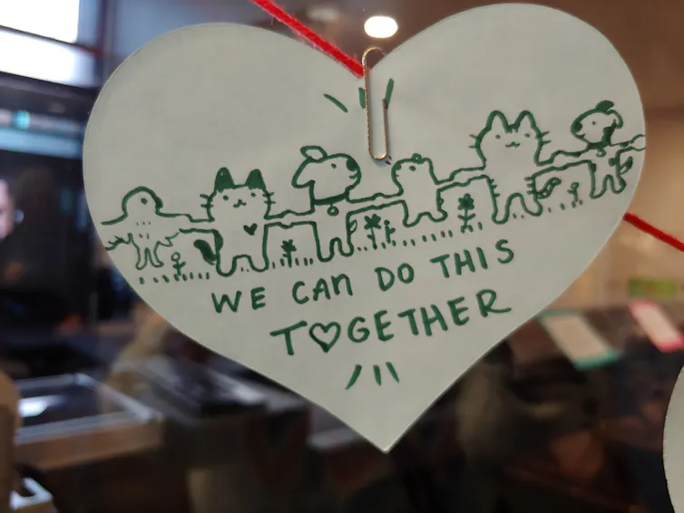 A wooden heart with green text and animated animals reads:
