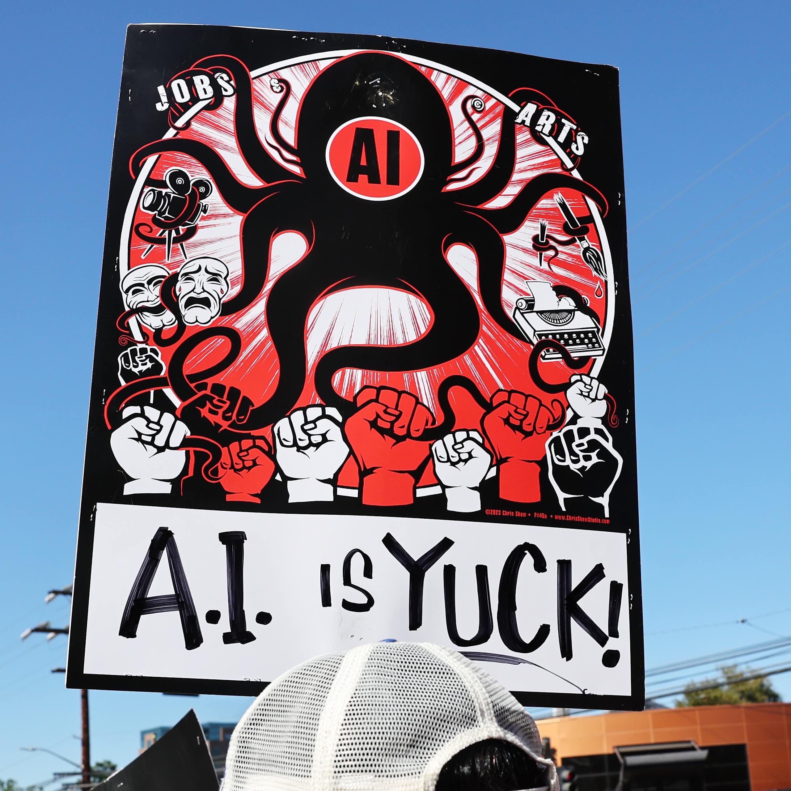 a protest sign depicting an octopus labelled AI
