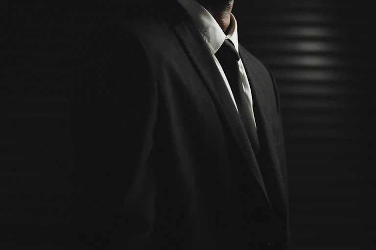 A man in a suit and tie, with no head showing.