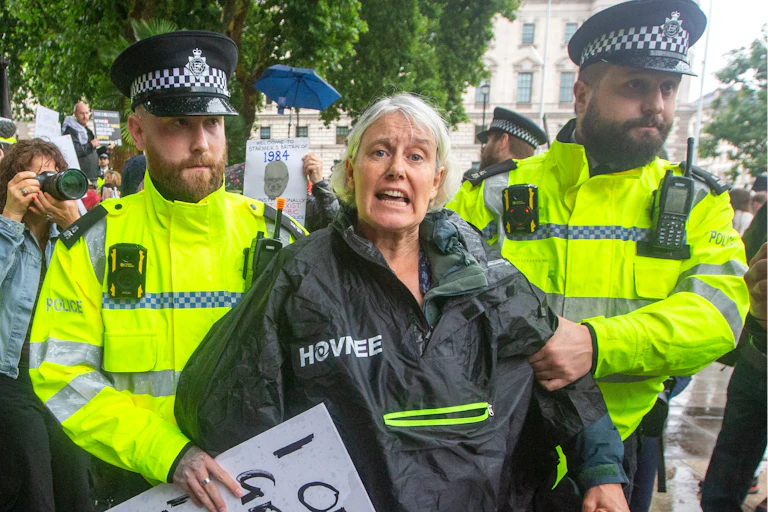 Older woman protestor arrested by two British police officers