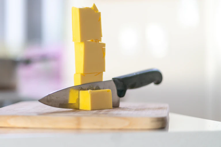 Knife cutting through cubes of butter.