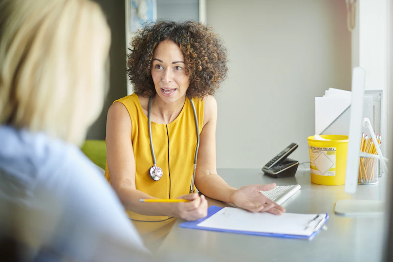 Woman seeing female GP, GP with stethoscope around neck