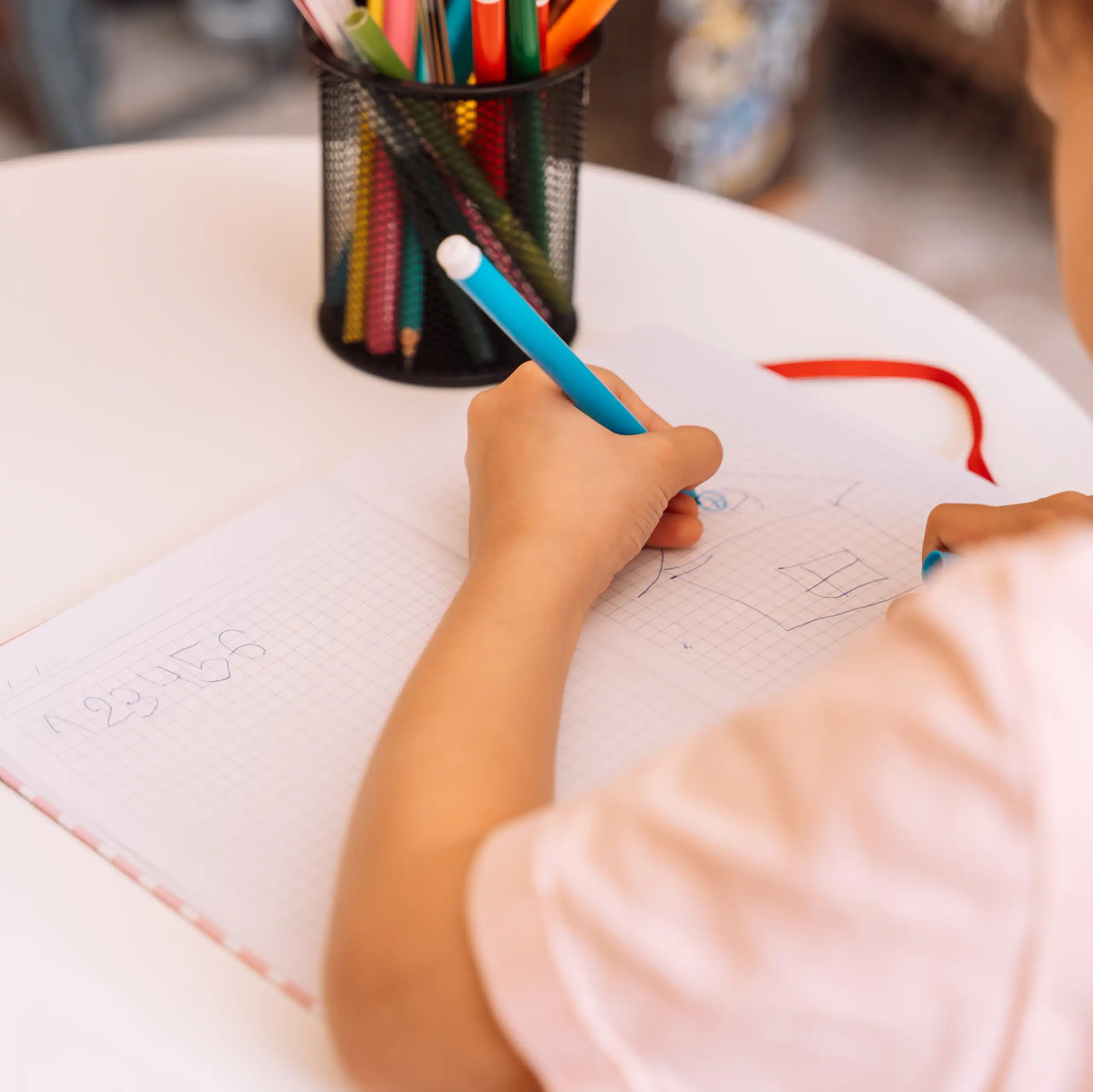 una niña dibuja en un cuaderno con su mano izquierda