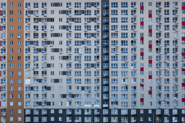 Fachada de un gran edificio repleta de ventanas y aparatos de aire acondicionado