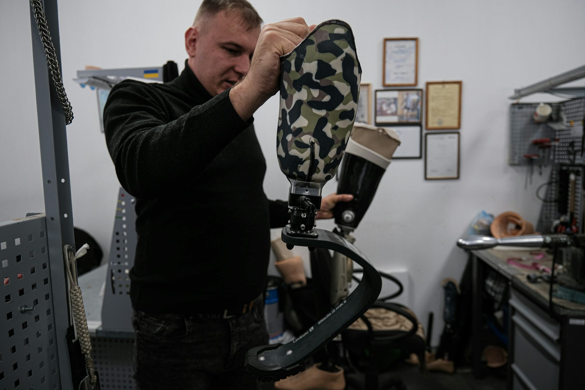 A man holds up a prosthetic leg.