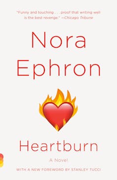 Book cover of 'Heartburn' by Nora Ephron. It's a white book with a small drawing of a heart on fire in the centre