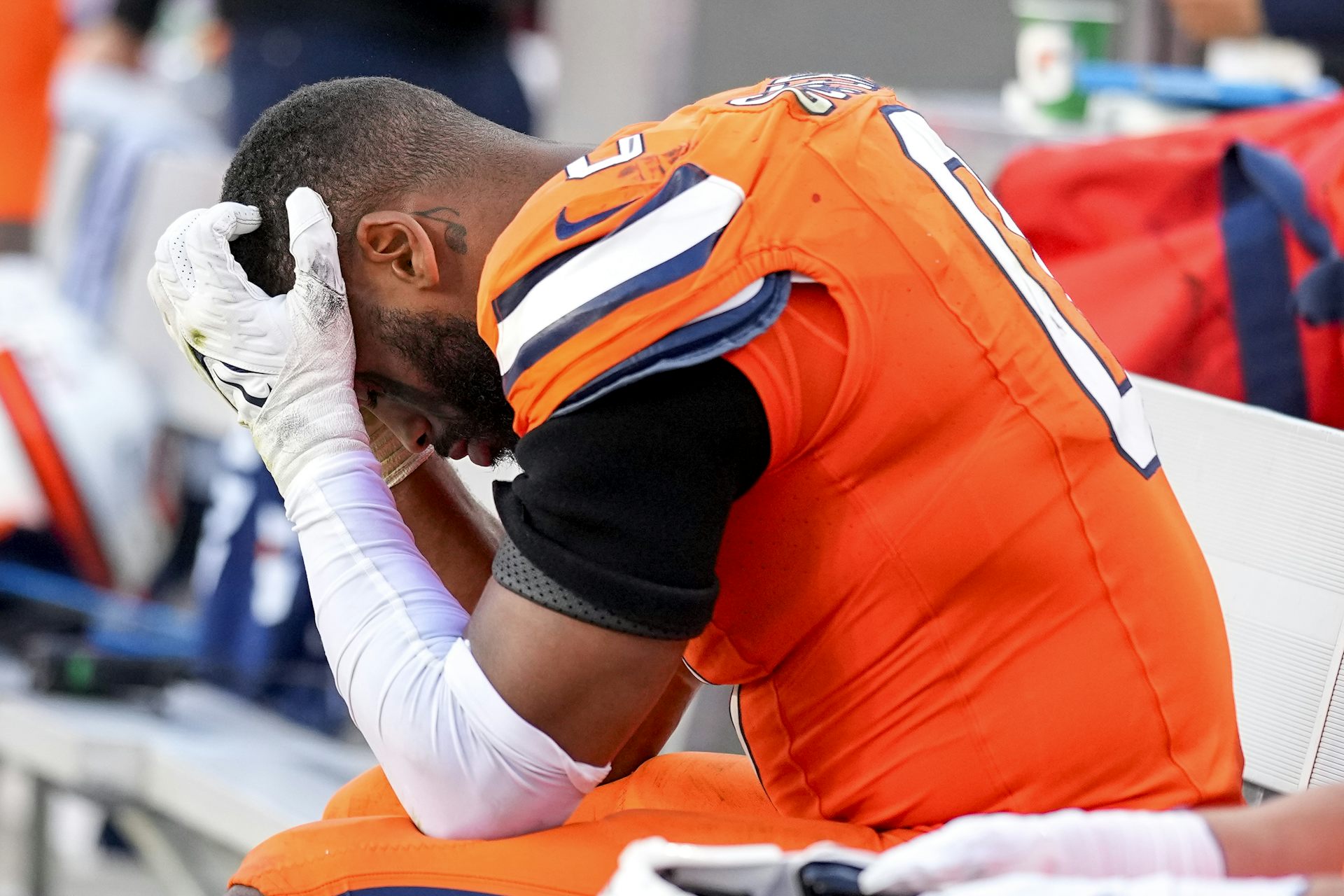 Jugador de fútbol en una camiseta naranja con cara en las manos.