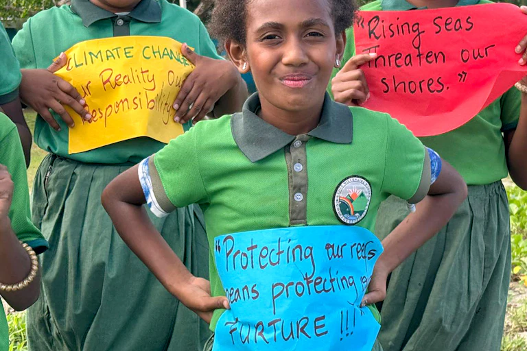 children in vanuatu holding signs about climate change.