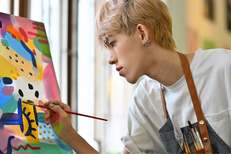 A trans teen paints