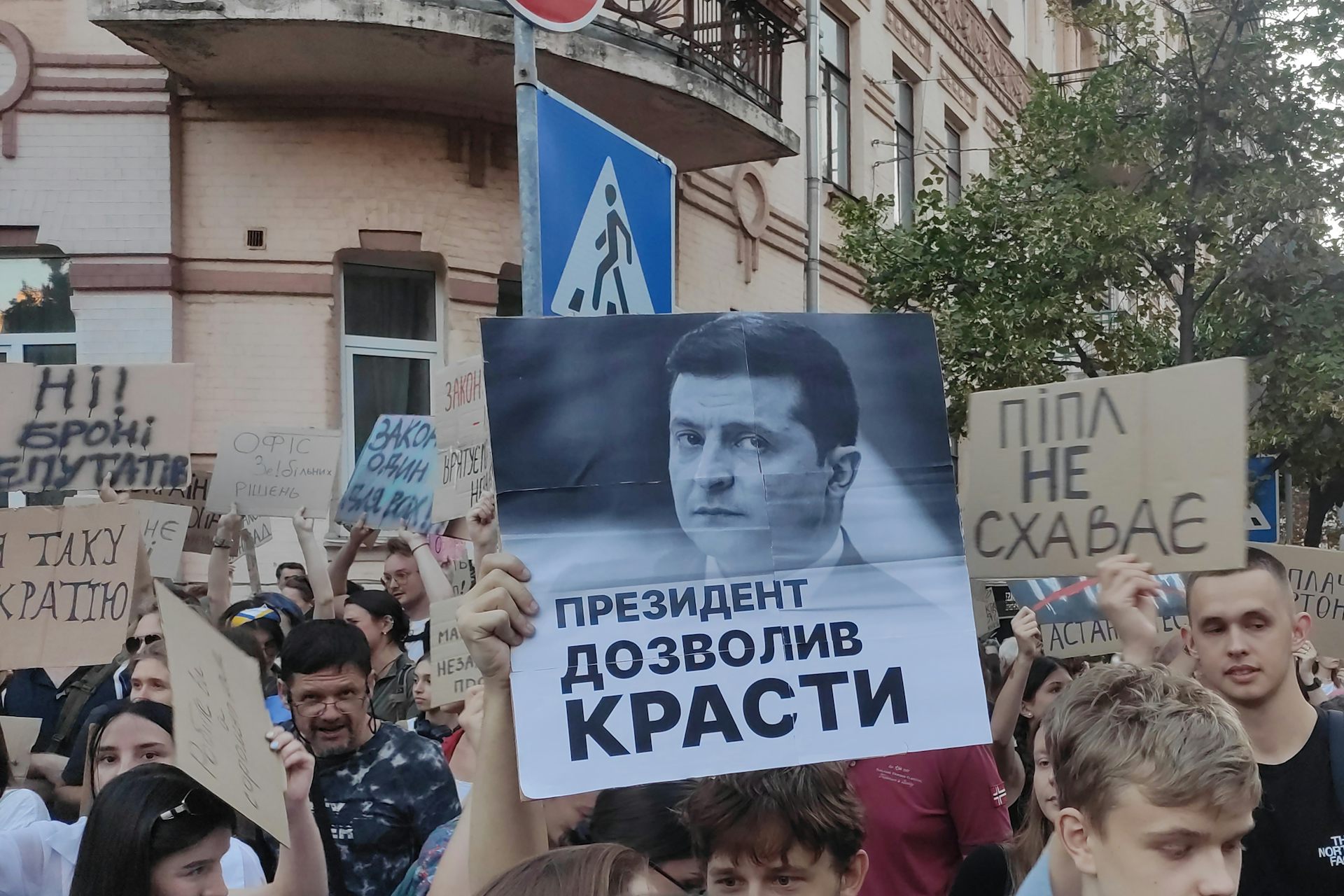 A crowd of protesters hold up banners and signs in the Ukrainian language.