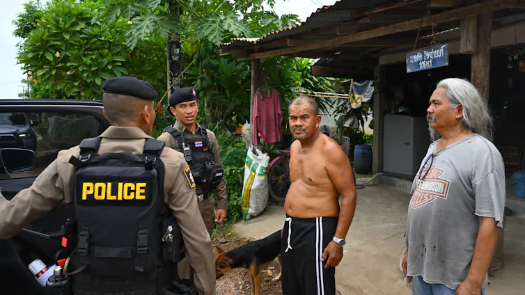 Thai police officers trying to convince villagers to evacuate.