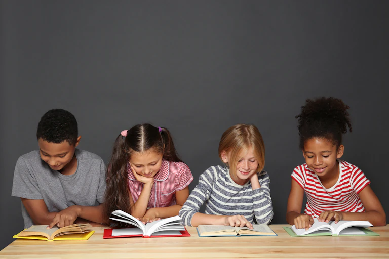 Quatre enfants en train de lire.
