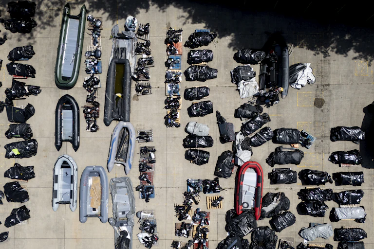 Overhead aerial view of inflatable dinghies laid out on concrete