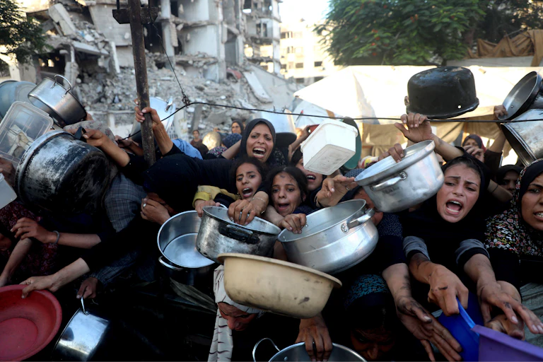 Desperate Palestinians queue for food in Gaza City, July 2025.