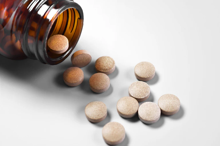 Pills spilling out of a brown bottle
