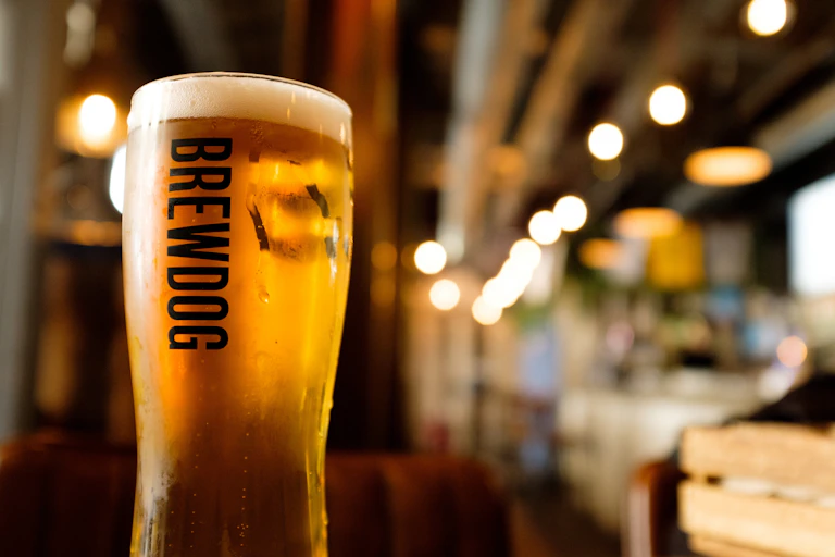 pint of beer in a brewdog-branded glass on a bar