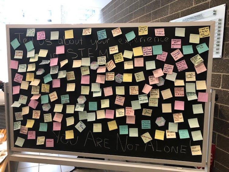 A chalkboard covered in post it notes.
