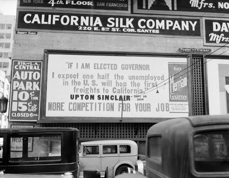 A black and white photo depicts a billboard criticizing Democrat Upton Sinclair.