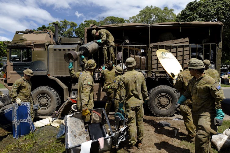 soldiers load items onto a truck