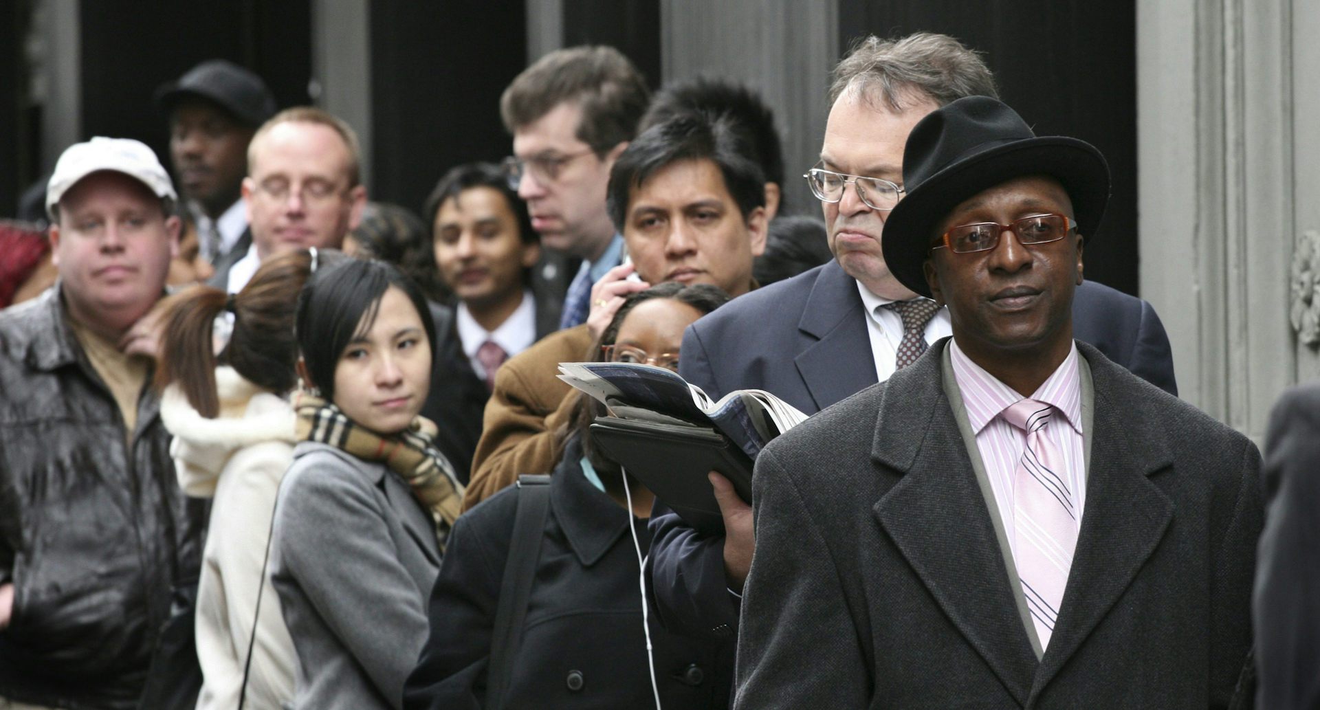 La gente está en línea con caras serias.