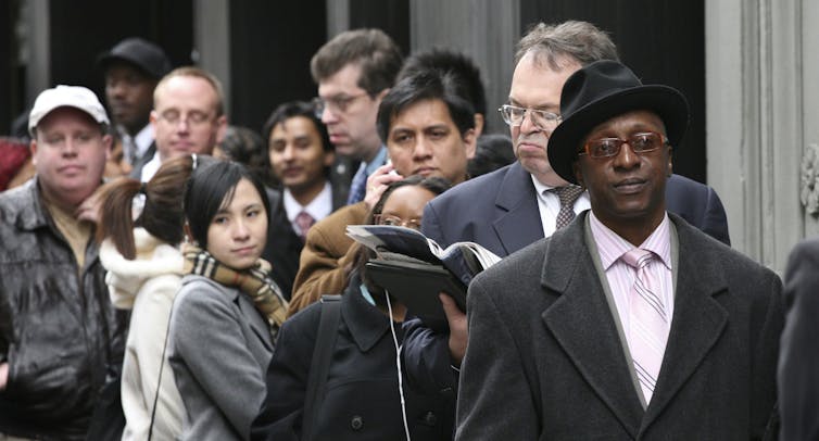 La gente está en línea con caras serias.