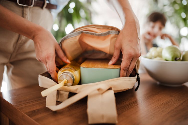 A parents packs her child's bag.