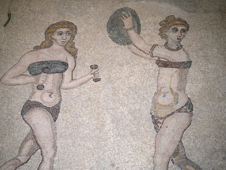 Roman mosaic of a woman with dumbbells and a woman lifting a ball exercising in bandeau bras.
