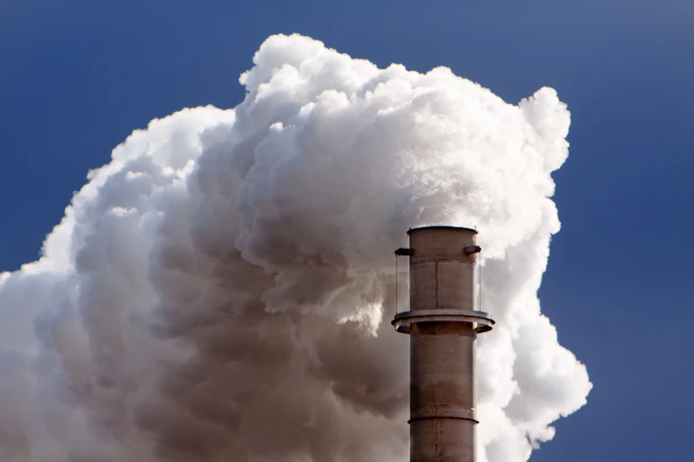 An industrial chimney belching white smoke.