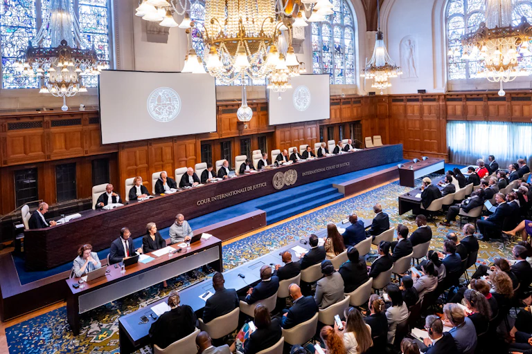 A room where 15 judges sit in front of a courtroom full of people