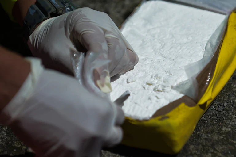 Members of the Colombian anti-narcotics police test cocaine after a drug bust.