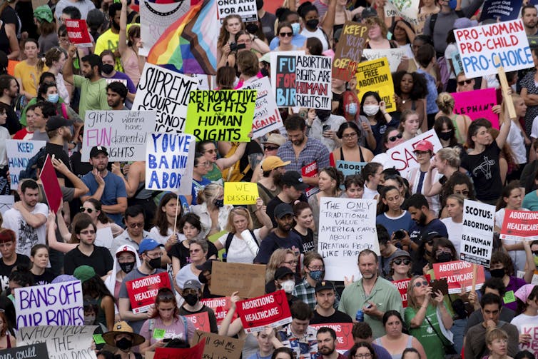 A large crowd with many homemade banners.