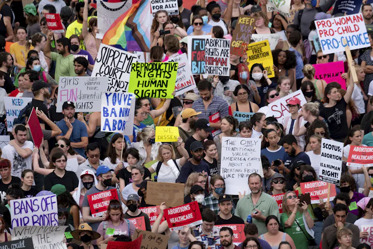 A large crowd with many homemade banners.