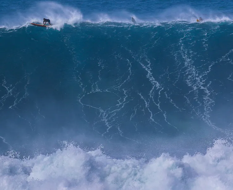 surfistas sobre una ola gigante