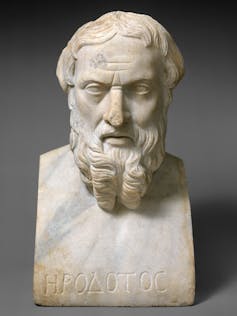 A marble bust of a bearded man with name Herodotus inscribed in Greek at the base.