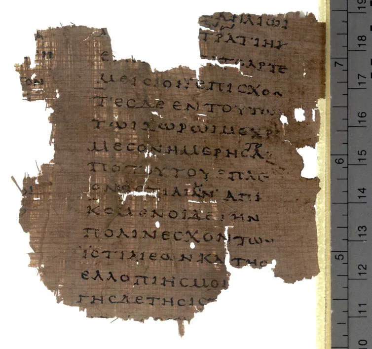 A scrap of dark brown fabric covered with Greek writing