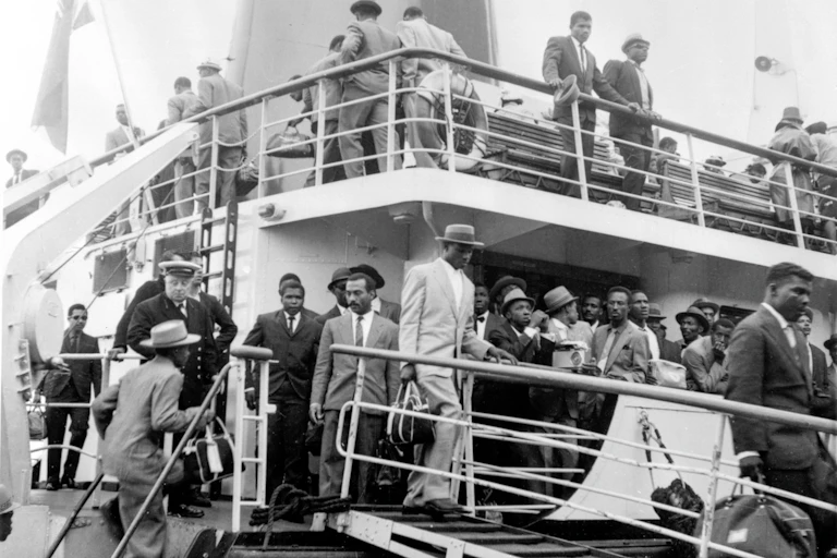 Black and white photo of men women and children from the Caribbean arriving at Southampton in 1962, part of the Windrush generation