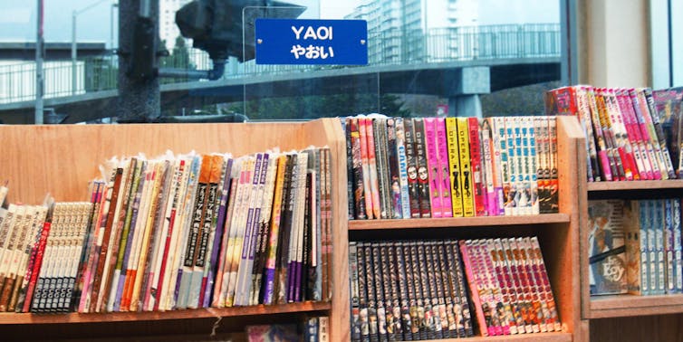Books are stacked on a shelf.