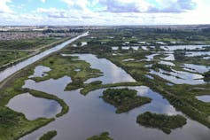 Foto aérea mostra rio com vários trechos de alagamentos