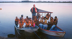 Foto mostra dois barcos pequenos em um rio, com vários pesquisadores com coletes salva-vidas