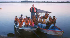 Foto mostra dois barcos pequenos em um rio, com vários pesquisadores com coletes salva-vidas