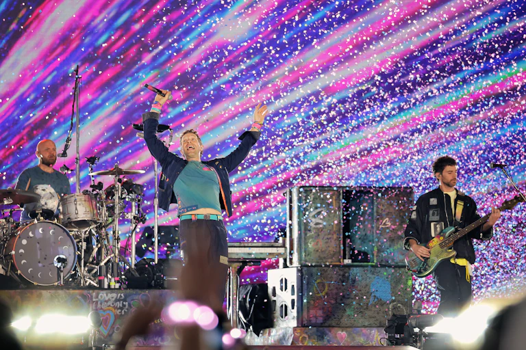 Coldplay perform in a concert.