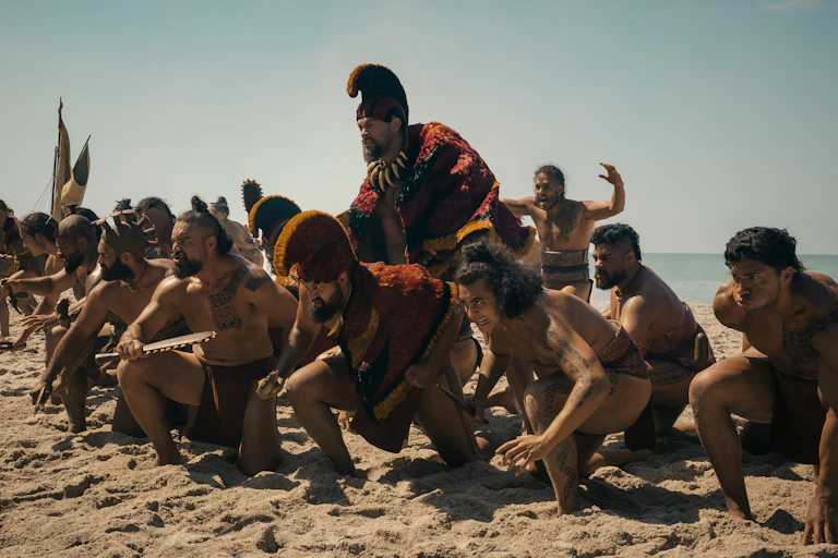 Jason Momoa and cast members of Chief of War in costume on beach