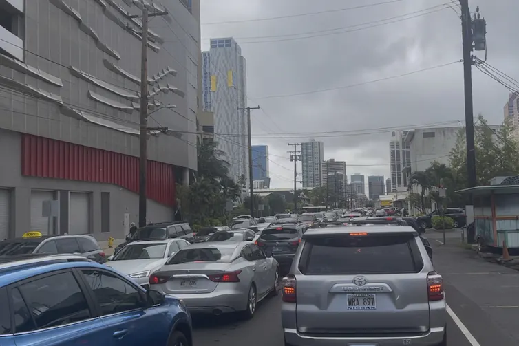 cars queue in city under stormy sky