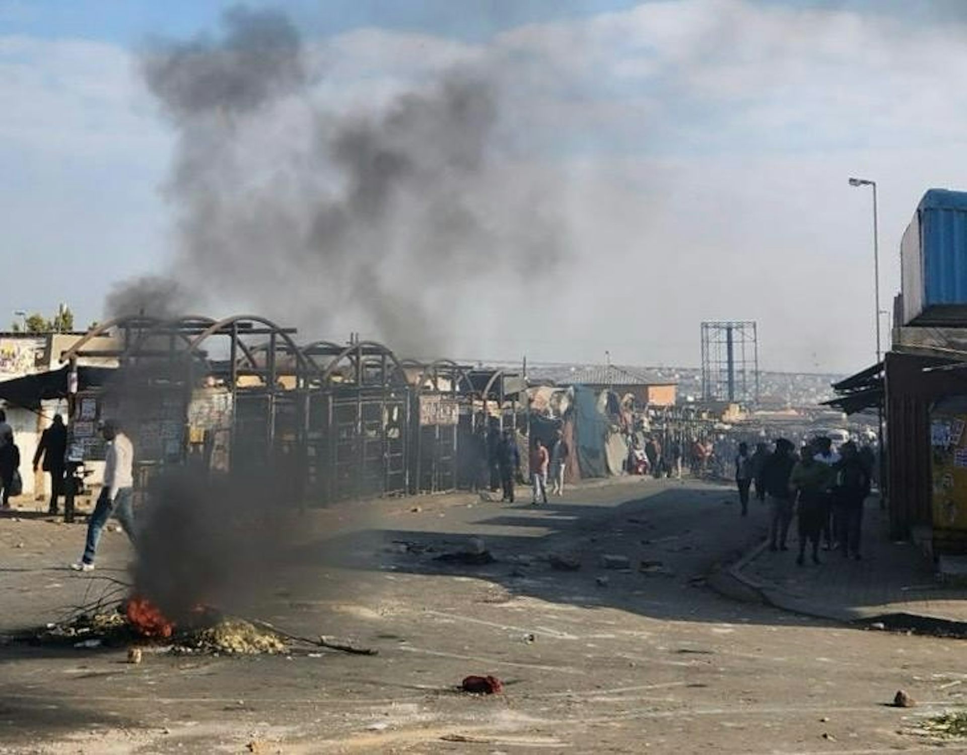Burning rubble in a street that is blocked off and closed down