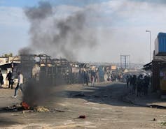 Burning rubble in a street that is blocked off and closed down