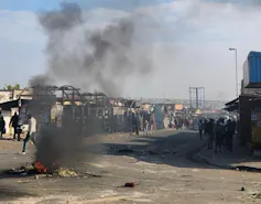 Burning rubble in a street that is blocked off and closed down