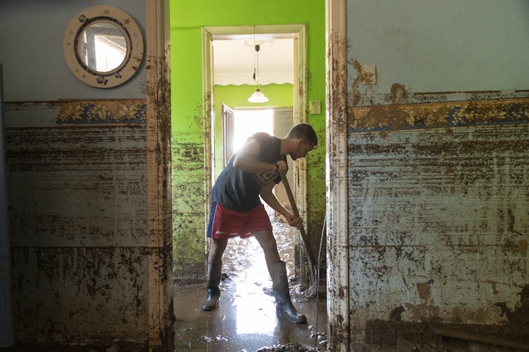 A man cleans up a flooded building